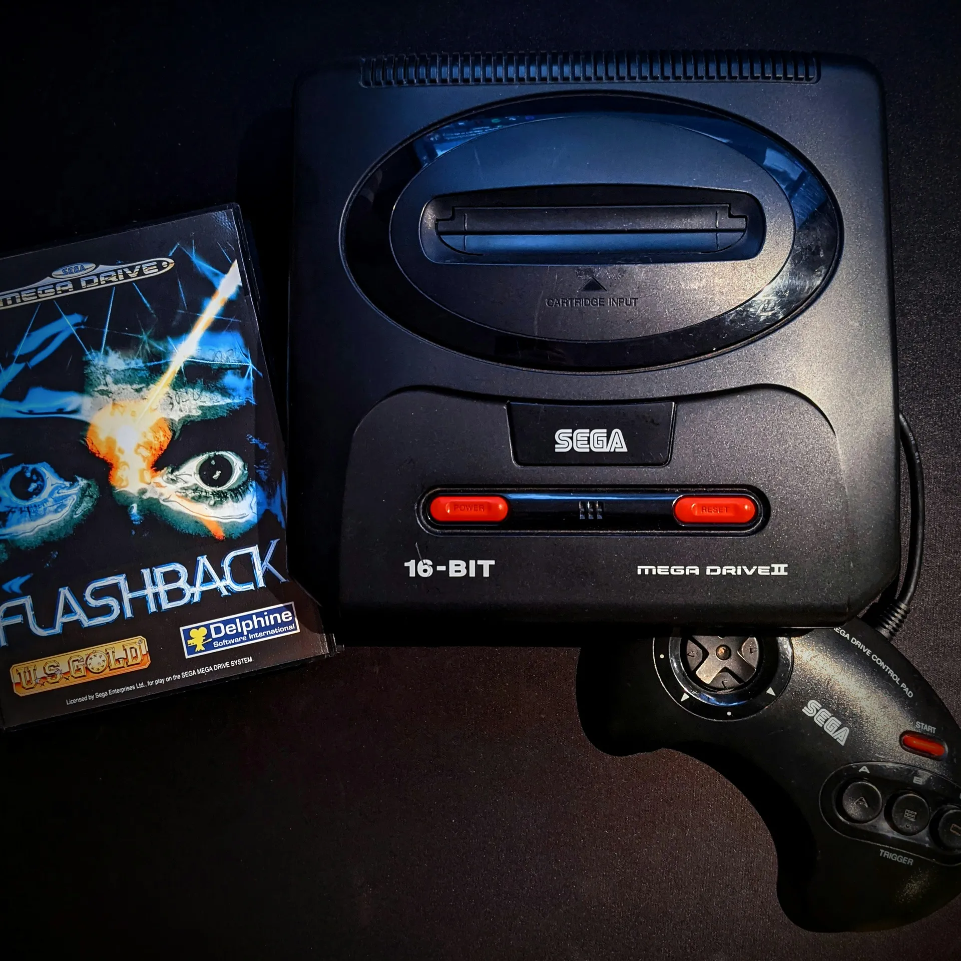 Console Sega Mega Drive accompagnée de sa manette et d’un jeu