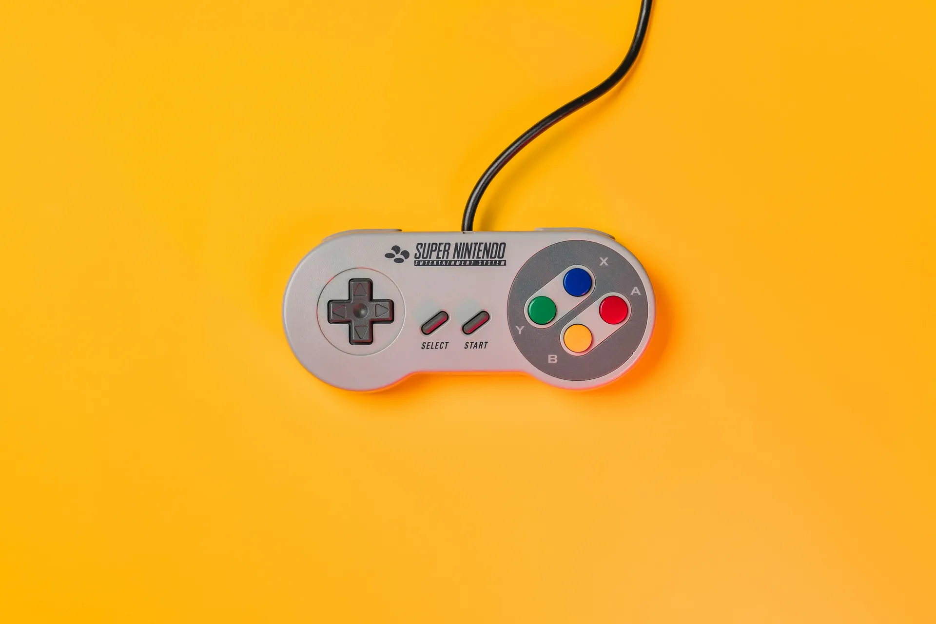Manette Super Nintendo sur fond jaune pour illustrer les jeux rétrogaming